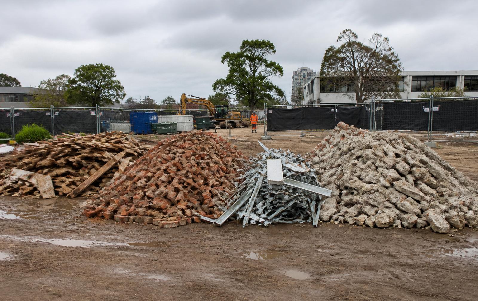 Separated piles of brick, timber, concrete and metal waste on a Melbourne demolition site ready for recycling